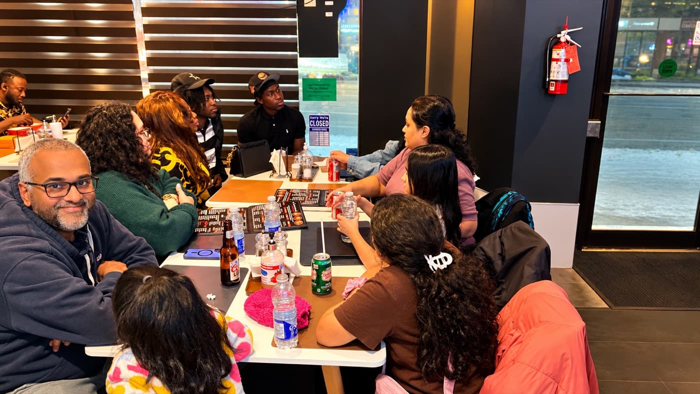 Guests sharing a meal together at a table in the Ghana Jollof dining room