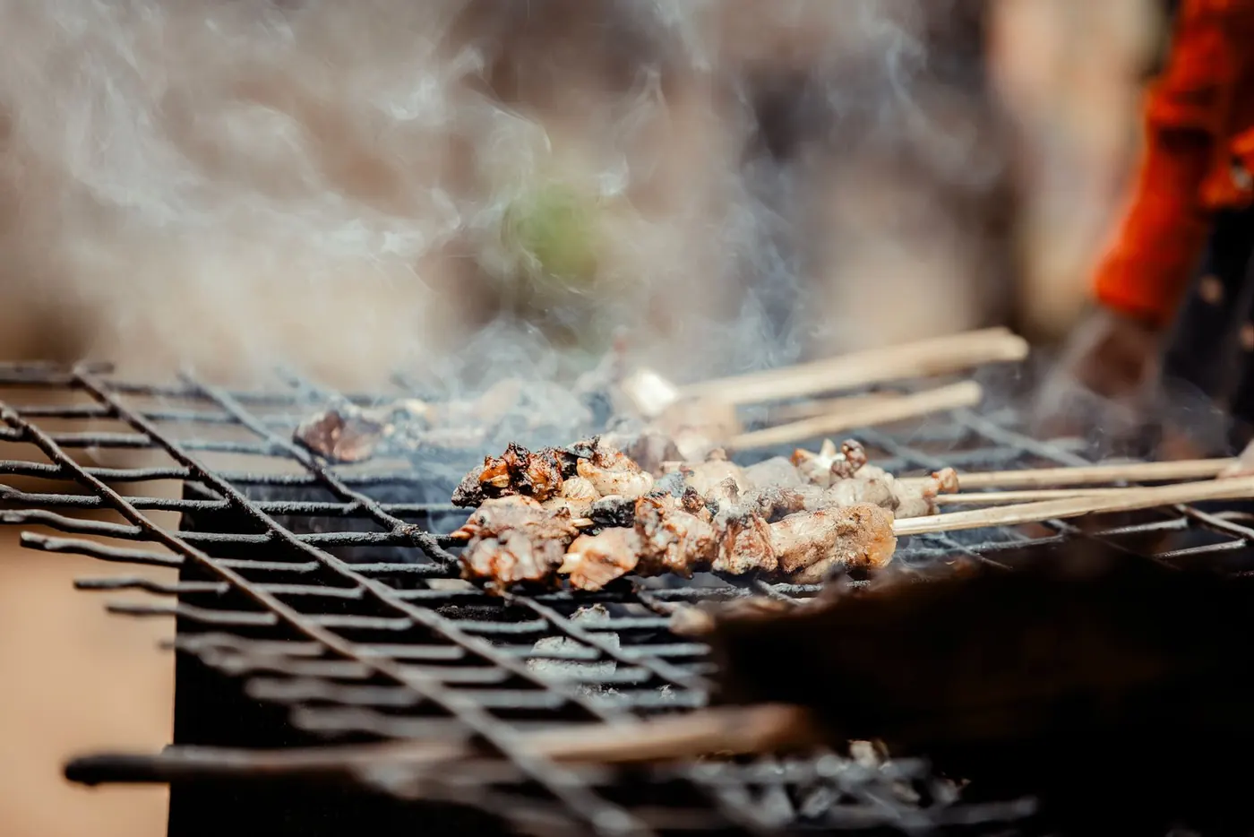 Suya skewers smoking on the grill
